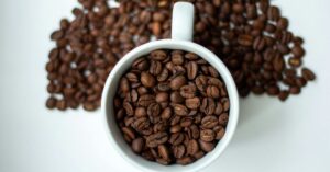 Top view of coffee beans spilling from cup