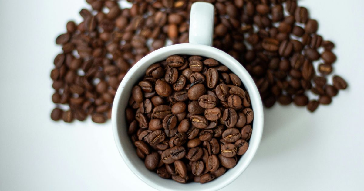 Top view of coffee beans spilling from cup