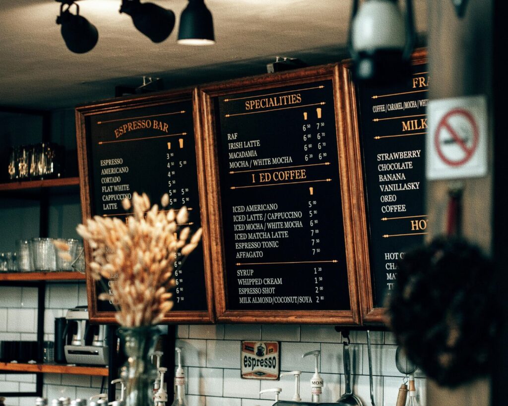 Wooden framed coffee shop menu board above counter.