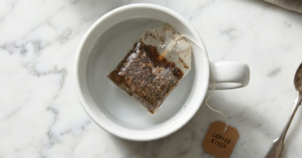 Coffee ground in a tea bag soaked in a mug with water