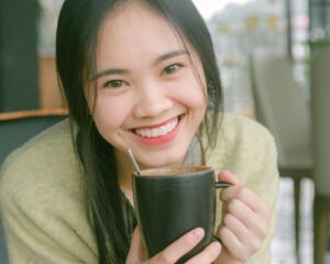 A Smiling Woman Holding Black Ceramic Mug