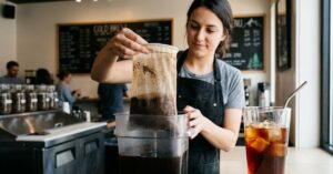 Barista lifting a cold brew filter bag.